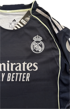 Load image into Gallery viewer, Real Madrid 2025-26 Youth Away Kit (Jersey + Shorts) - Adidas Champions League close-up of the Real Madrid logo embroidered with the three stripes on the shoulders