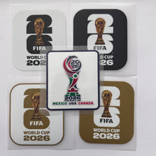 Load image into Gallery viewer, Five FIFA World Cup 2026 merchandise stickers or decals arranged on a white background, including two black-and-white designs, two gold-and-white designs, and one central white sticker with the official tournament emblem and country text Mexico, USA, Canada.