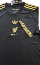 Load image into Gallery viewer,  "Mexico 2025 Black & Gold Jersey Side Profile - Mexico de Oro Adidas Originals Special Edition with Premium Gold Trim and Official El Tri Styling" with arm design