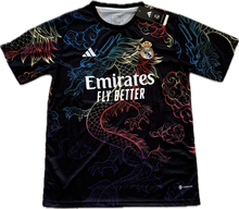 Load image into Gallery viewer, Black sports jersey with colorful dragon design and Emirates branding Bellingham