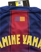 Load image into Gallery viewer, Blue and red sports jersey with a flag and text on a white background "Nike FC Barcelona 2025-26 Youth Home Jersey - Lamine Yamal #10 Detail"

